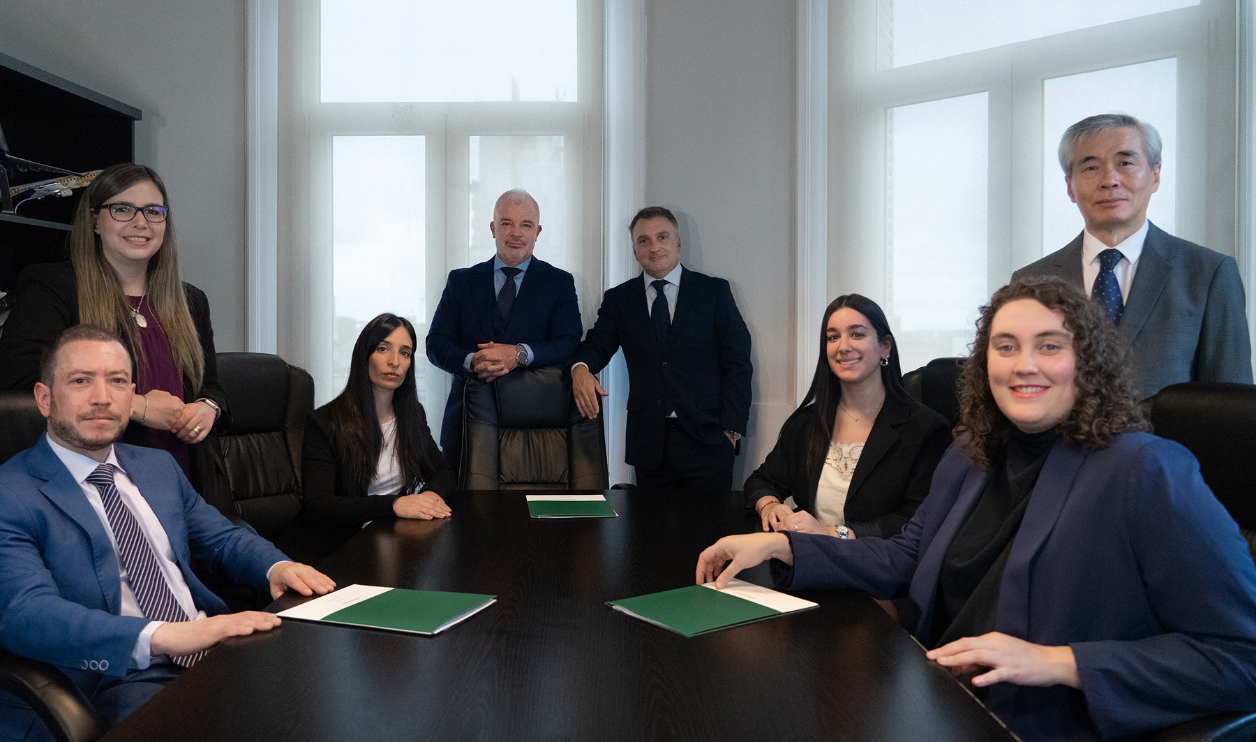 Equipo de Yelpo & Facal en sus oficinas. Los socios fundadores Julio Facal y Gonzalo Yelpo de pie, rodeados por sus abogados asociados y procuradores en una mesa de reuniones.