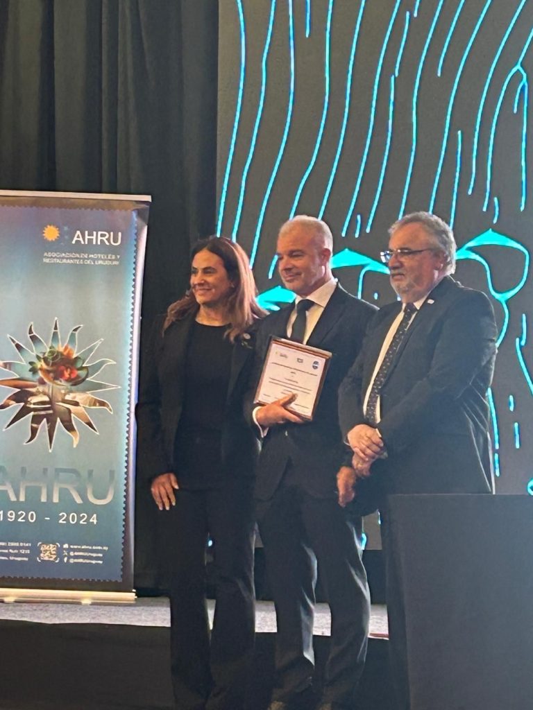 Julio Facal recibiendo su premio junto a dos figuras de la Asociación de Hoteles y Restaurantes del Uruguay. 